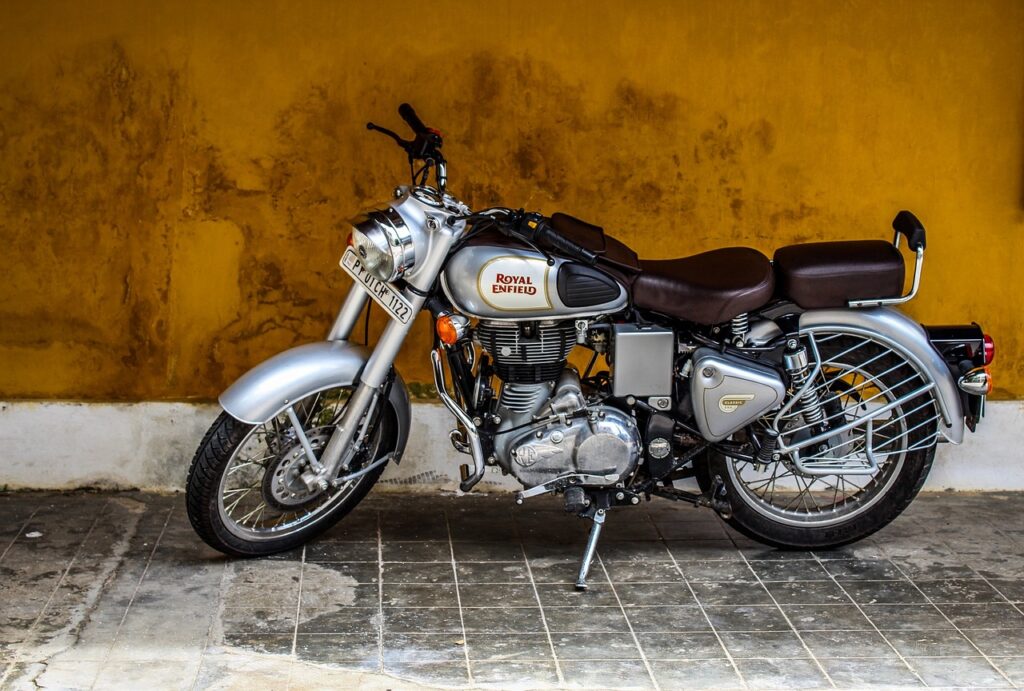 オレンジの壁を背景に置いてあるバイクの画像