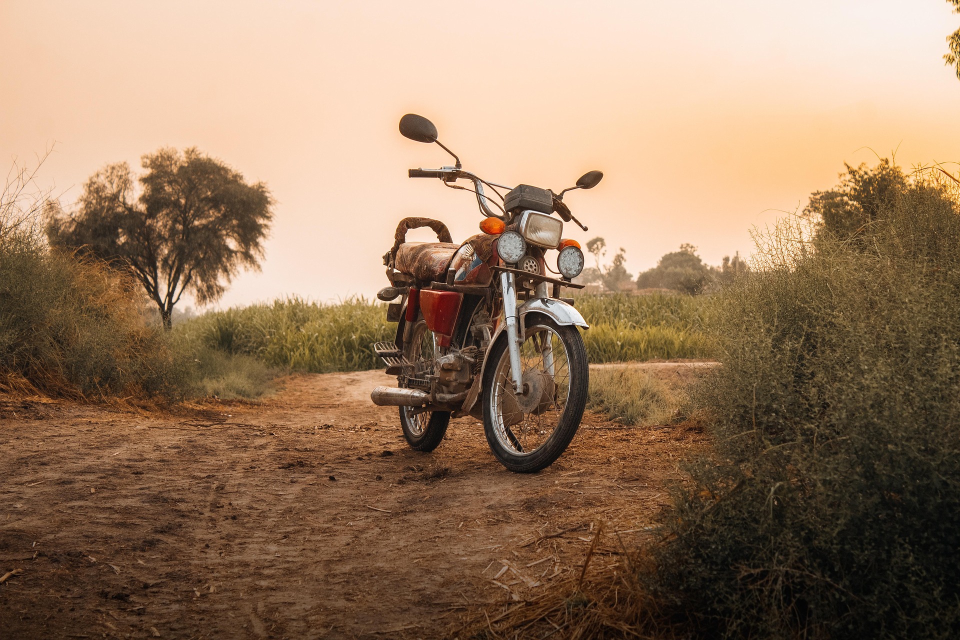 自然の山の中で、夕日をバックにしたバイクの画像